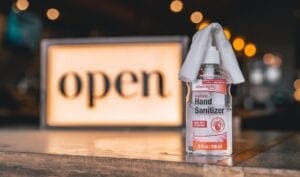 hand sanitizer next to open sign