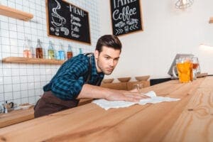 man cleaning restaurant counter