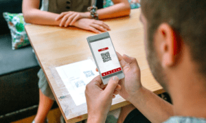 man using cell phone looking at QR codes
