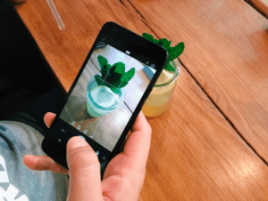 person taking a photo of their drink with an iphone