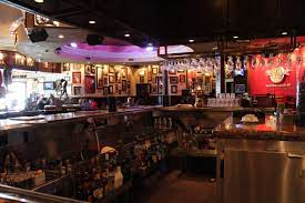 an empty bar at a restaurant with pink neon lighting