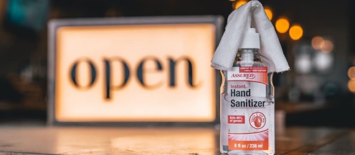 hand sanitizer next to open sign