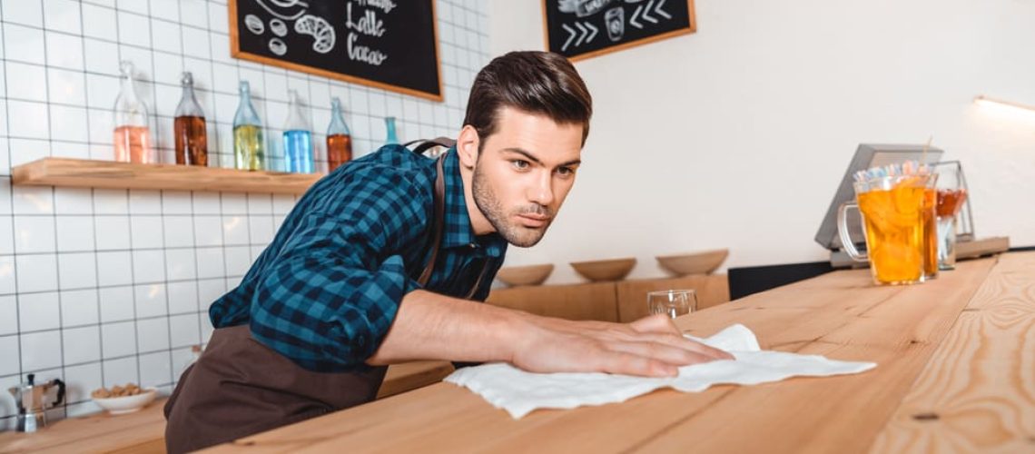 man cleaning restaurant counter